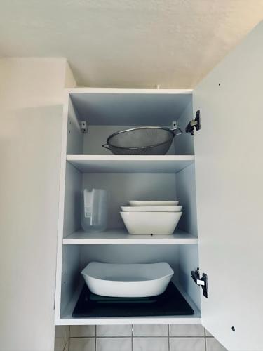 a cupboard with a bowl and bowls on it at Apartment NeuenHOUSE II Garten & Ruhig in Neuenhaus