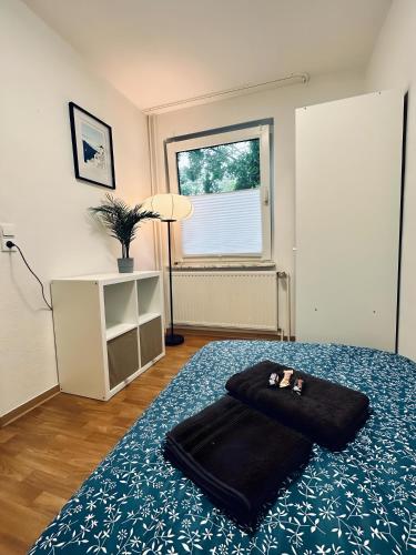 a bedroom with a bed with a black towel on it at Apartment NeuenHOUSE II Garten & Ruhig in Neuenhaus
