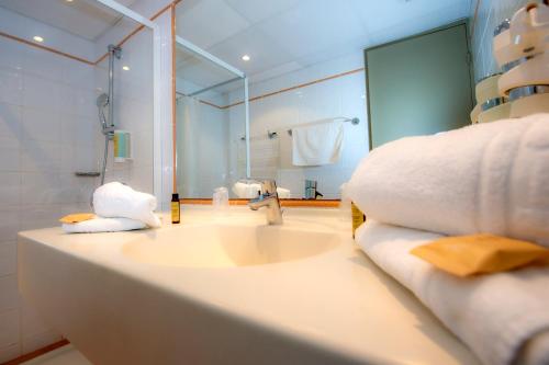 a bathroom with a sink and a shower and a mirror at Club Vacances Bleues Domaine de Ch&acirc;teau Laval in Gr&eacute;oux-les-Bains