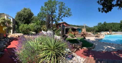 un jardin avec des plantes violettes et une piscine dans l'établissement Les Mazets du coulicot, à Saint-Montan