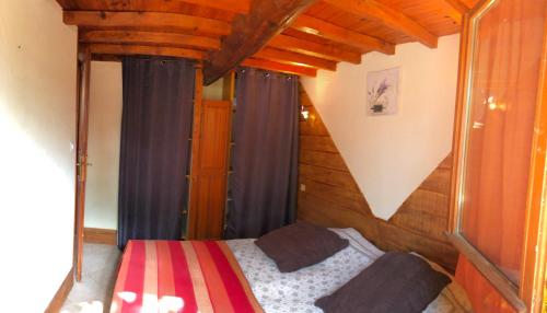 une chambre avec un lit dans une pièce aux murs en bois dans l'établissement Les Mazets du coulicot, à Saint-Montan