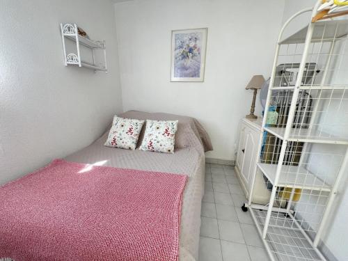 - une petite chambre avec un lit et un tapis rose dans l'établissement Sol-y-Days Martinic, résidence à deux pas des plages, à La Grande Motte