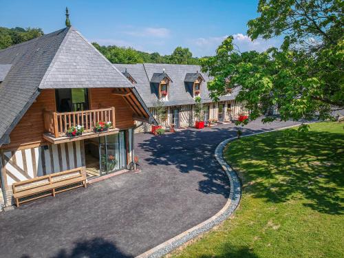a large house with a porch and a driveway at Le Domaine d’Angerville - Le Gîte in Dozulé