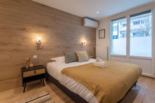 une chambre avec un grand lit avec un mur en bois dans l'établissement Le Villa Nova au centre ville, à Annecy