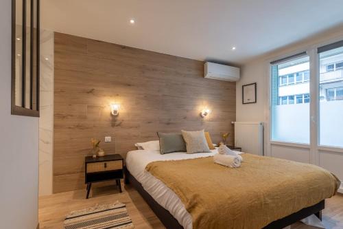 une chambre avec un grand lit avec un mur en bois dans l'établissement Le Villa Nova au centre ville, à Annecy