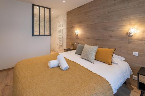 une chambre avec un grand lit avec un mur en bois dans l'établissement Le Villa Nova au centre ville, à Annecy