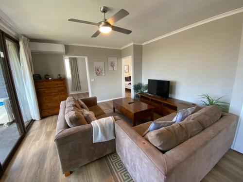a living room with two couches and a ceiling fan at Family friendly 4BR Apartment near Mt Stromlo - Hosted by Canstay in Weston Creek