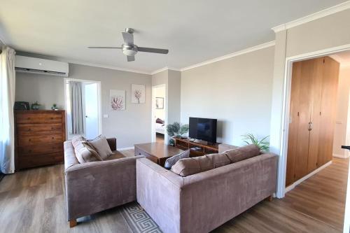 a living room with a couch and a tv at Family friendly 4BR Apartment near Mt Stromlo - Hosted by Canstay in Weston Creek