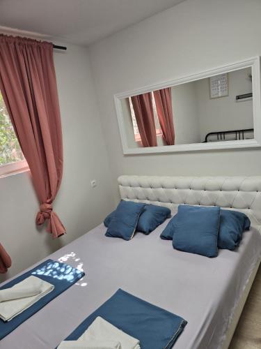 a bedroom with a bed with blue pillows and a mirror at Amelie & Sea - Ground Floor Penthouse with 2 Terraces, Green Views, Sleeps 9 in Vir