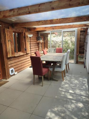 - une table à manger et des chaises sur la terrasse dans l'établissement Chalet en bois dans la forêt, à Riez