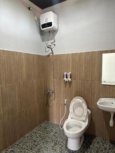 a bathroom with a toilet and a sink at Hotel Any Lestari in Huu