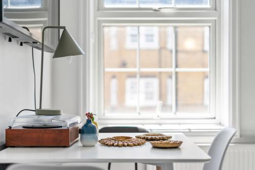 a table with cookies and a lamp and a window at The Anchor in Kings Cross ZONE 1 !!! in London