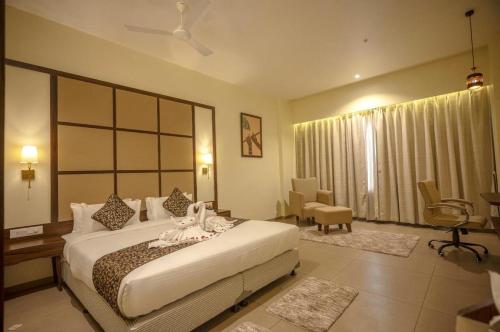 a hotel room with a bed and a chair at Hotel Utsav Square in Latur