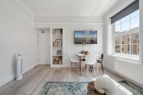 a white living room with a table and chairs at The Anchor in Kings Cross ZONE 1 !!! in London