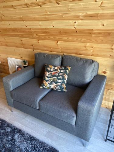 a couch in a room with a wooden wall at Fernhill Valley Farm in Blaencwm
