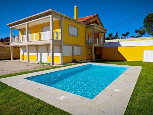 a yellow house with a swimming pool in front of it at Encanto de Arcos de Valdevez 1 in Arcos de Valdevez