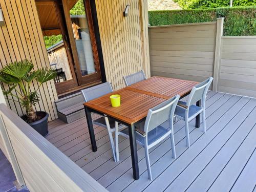 a wooden table and chairs on a deck at Le Plein Sud in Stoumont