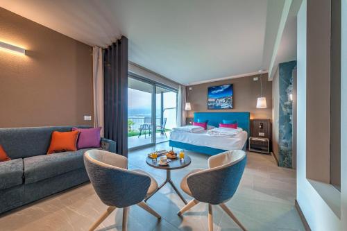 a hotel room with a bed and a couch at Sky View Garda Lake by Hotel Galvani in Torri del Benaco