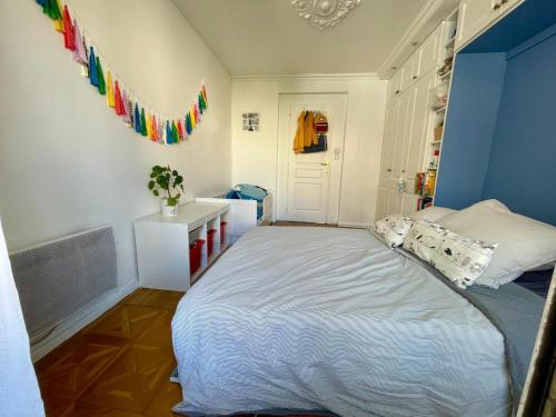 a bedroom with a bed and a table and flags at 2 BEDROOMS & TERRACE with BBQ COURBEVOIE PARIS in Courbevoie
