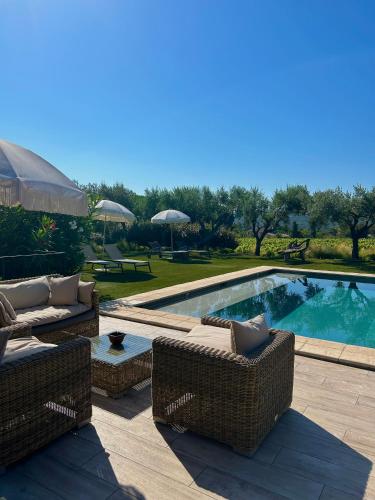 - une piscine avec 2 chaises en osier à côté dans l'établissement Auberge de l'Oumède, à Saint-Tropez