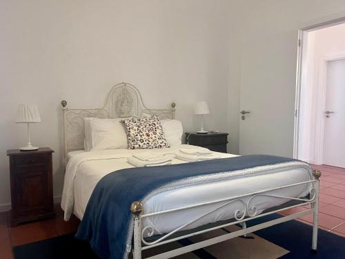 a bedroom with a bed with a blue blanket and two lamps at Imperial Douro Apartamento 1 in Peso da Régua