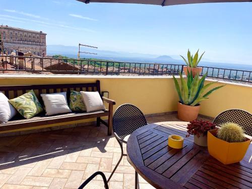 a patio with a table and bench on a balcony at Casa Checca e Casa Maria appartamenti per vacanze in Caprarola