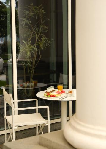 a table and chair with a plate of food on it at Le Port Boutique Apart Hotel in Batumi