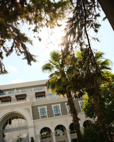 a building with a palm tree in front of it at Le Port Boutique Apart Hotel in Batumi