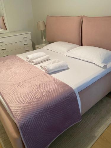 a bedroom with a bed with two towels on it at Mina Apartment in Tirana