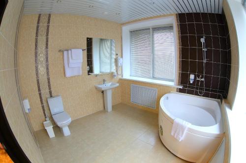 タンボフにあるHotel Tambovskayaのバスルーム(バスタブ、トイレ、シンク付)