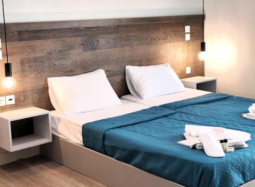 a bedroom with a bed with a blue blanket at Joanna Deluxe Apartments in Kynopiástai