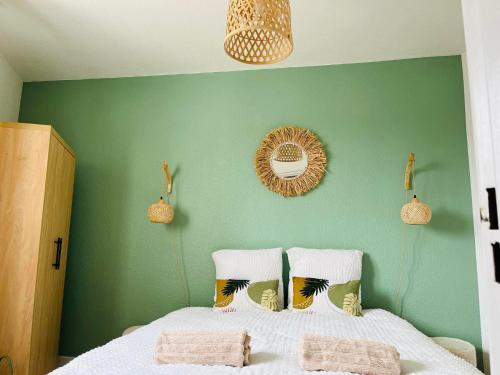 1 dormitorio con paredes verdes y 1 cama con 2 almohadas en L'évasion, en Le Barcarès