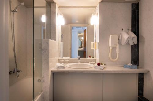 a bathroom with a sink and a shower at Aquila Porto Rethymno in Rethymno Town