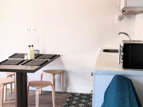 a kitchen with a table and stools in a room at Joanna Deluxe Apartments in Kynopiástai