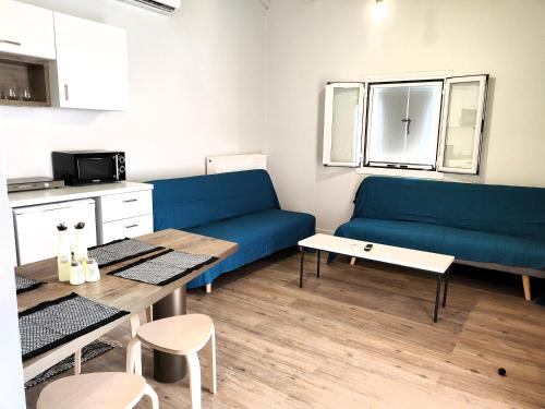 a living room with a blue couch and a table at Joanna Deluxe Apartments in Kynopiástai