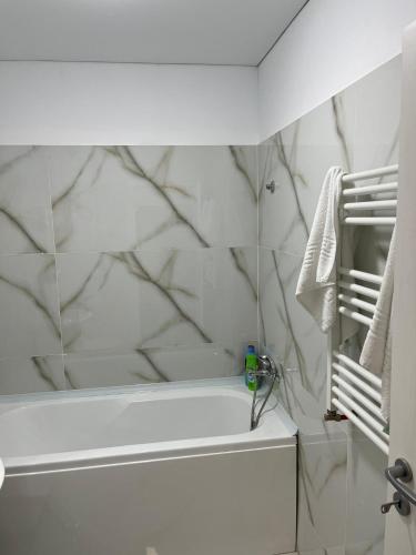 a bathroom with a white tub and marble walls at Pollux Residence Militari ap 113 in Dudu