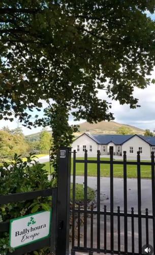 a gate in front of a white house at Ballyhoura Farm Escape Experience with Alpacas & Fairy Forest in Ballyorgan