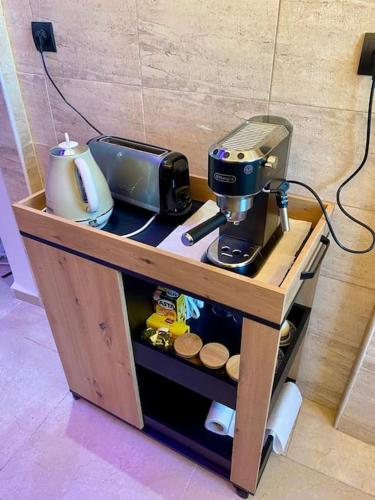 a small wooden table with a coffee maker on it at Magnifique Appart Tanger Vue Mer Plage à 100m Calme et Nature in Tangier