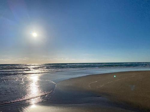 a beach with the sun rising over the ocean at Magnifique Appart Tanger Vue Mer Plage à 100m Calme et Nature in Tangier