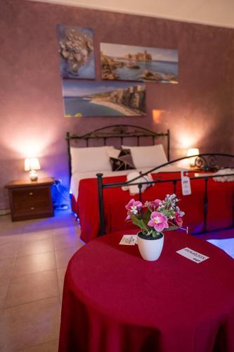 a room with two beds and a table with flowers on it at B&B Villa Maracujà in Ionadi