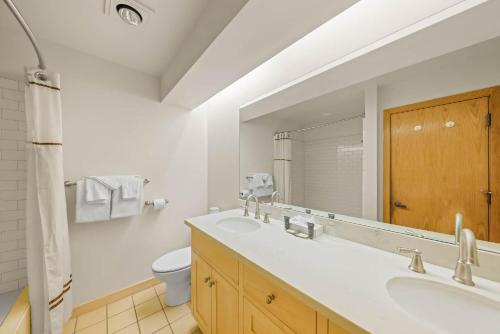 Un baño con lavabo, inodoro y espejo. en Palisades Tahoe Lodge Rentals Studio Loft #346, en Olympic Valley