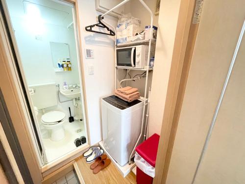 baño pequeño con aseo y microondas en シャンテ高田馬場11, en Tokio