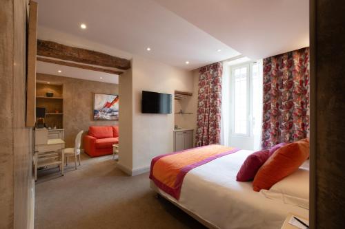 une chambre avec un lit et un bureau dans une pièce dans l'établissement Hôtel Golf & Spa Château de la Bégude The Originals Collection, à Valbonne