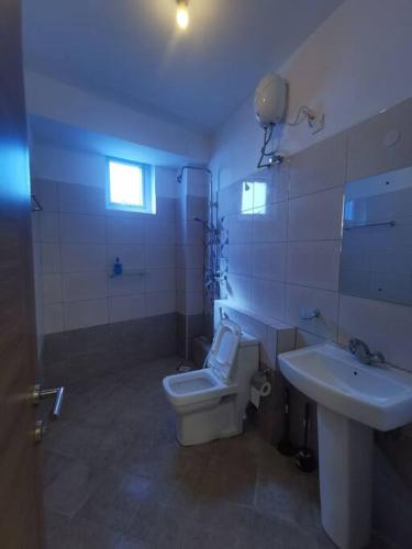 a bathroom with a white toilet and a sink at Seaview Penthouse, AC included & Rooftop Pool in Mombasa
