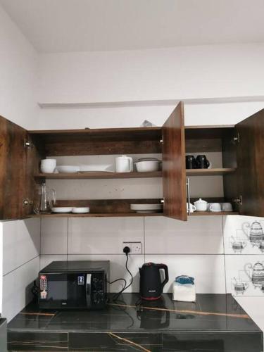 a kitchen with a counter top with a microwave at Seaview Penthouse, AC included & Rooftop Pool in Mombasa