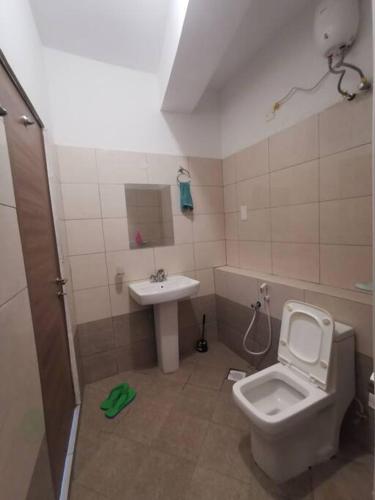a bathroom with a toilet and a sink at Seaview Penthouse, AC included & Rooftop Pool in Mombasa