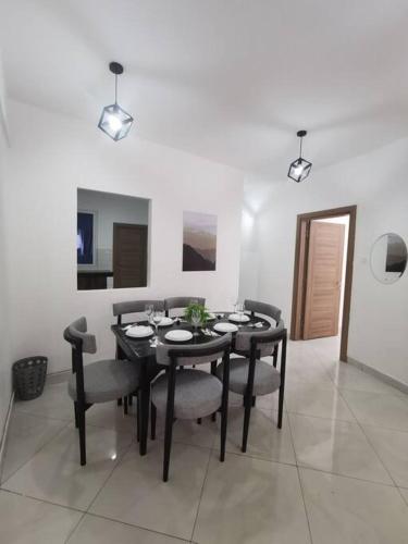 a dining room with a black table and chairs at Seaview Penthouse, AC included & Rooftop Pool in Mombasa