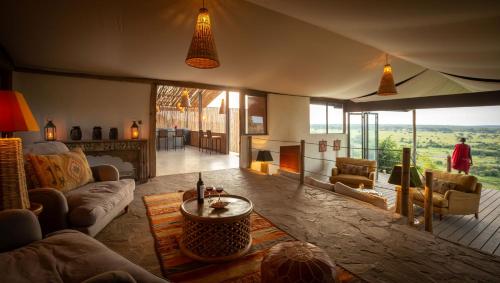 a living room with a couch and a fireplace at Saruni Eagle View in Naboisho