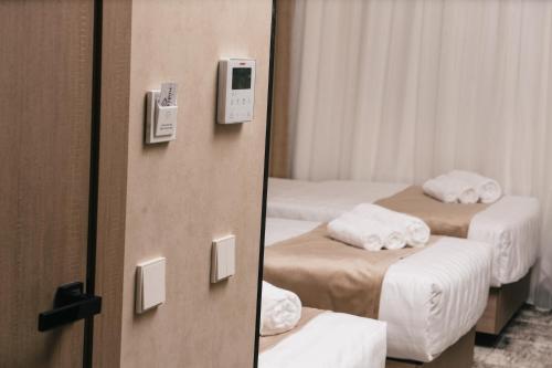 a hotel room with two beds and a mirror at Grand Castle Hotel in Urganch