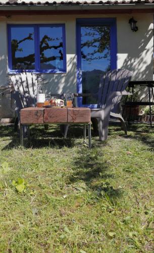 une table et deux chaises devant une maison dans l'établissement Entre Auvergne et Provence, à Jaujac